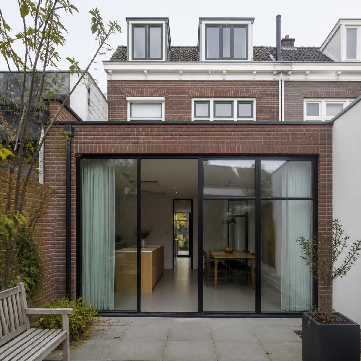Uitbouw met grote pui en zicht op de tuin.